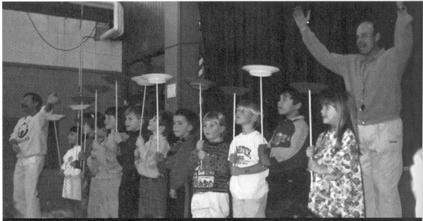 Finnigan (far end) and a happy teacher present their kindergarten-level plate spinners to the rest of the school.