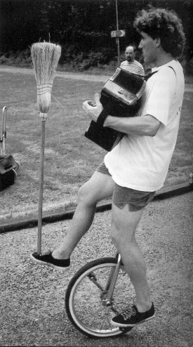(Right) Peter Weiss accompanies himself on accordian as he rides a unicycle and balances a broom.  (John Nations photo)